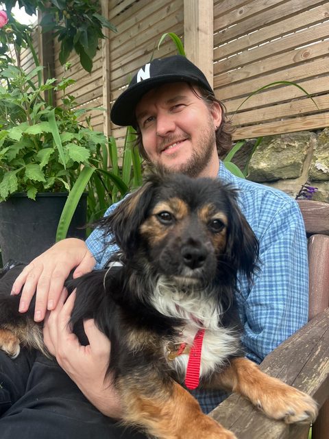 Paul sitting outside with his dog